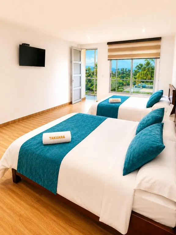 Habitación Doble Deluxe del Hotel Takuara con dos camas y balcón